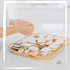 Artisan arranging handcrafted seashell perfume compacts filled with solid perfume blends made from pure essential oils.