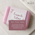French Lilac soap bar sitting on countertop next to a towel. 